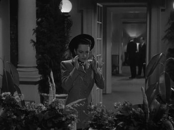 Movie still from “The Dark Mirror” (1946), directed by Robert Siodmak – An old photo of a woman taking a picture in a room; Medium shot, High angle