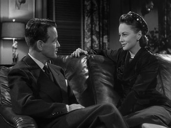 Movie still from “The Dark Mirror” (1946), directed by Robert Siodmak – A man and a woman sitting on a leather chair; Medium shot, High angle