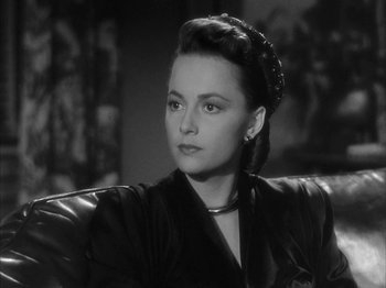 Movie still from “The Dark Mirror” (1946), directed by Robert Siodmak – A black and white photo of a woman sitting on a couch; Close Up shot, High angle