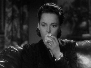 Movie still from “The Dark Mirror” (1946), directed by Robert Siodmak – A black and white photo of a woman eating a sandwich; Close Up shot, High angle