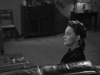 Movie still from “The Dark Mirror” (1946), directed by Robert Siodmak – A black and white photo of a woman sitting on a couch; Close Up shot, High angle