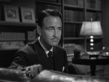 Movie still from “The Dark Mirror” (1946), directed by Robert Siodmak – A man sitting at a table in a room; Close Up shot, Low angle