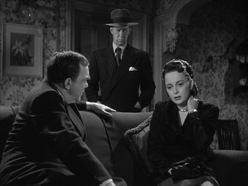 Movie still from “The Dark Mirror” (1946), directed by Robert Siodmak – Two men and a woman sitting on a couch in front of a door; Medium shot, Over the shoulder angle