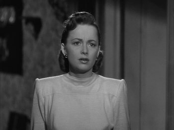 Movie still from “The Dark Mirror” (1946), directed by Robert Siodmak – A black and white photo of a woman in a white dress; Close Up shot, Over the shoulder angle