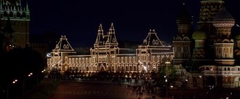 Movie still from “The Darkest Hour” (2011), directed by Chris Gorak – People are walking in front of a building lit up at night; Extreme Wide shot, High angle