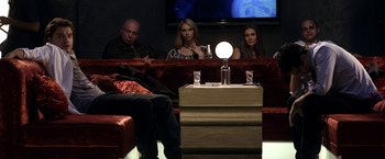 Movie still from “The Darkest Hour” (2011), directed by Chris Gorak – A group of people sitting on a couch in a living room; Wide shot, Over the shoulder angle