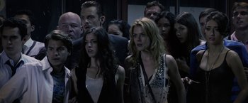 Movie still from “The Darkest Hour” (2011), directed by Chris Gorak – A group of people standing around each other in a room; Close Up shot, High angle