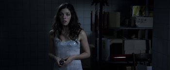 Movie still from “The Darkest Hour” (2011), directed by Chris Gorak – A woman in a white dress is holding a remote control; Medium shot, Over the shoulder angle