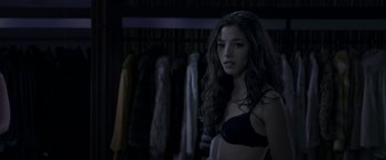 Movie still from “The Darkest Hour” (2011), directed by Chris Gorak – A woman in a black bra standing in a room; Close Up shot, Over the shoulder angle