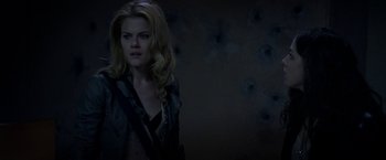 Movie still from “The Darkest Hour” (2011), directed by Chris Gorak – A woman with long blonde hair standing in a dark room; Medium shot, Over the shoulder angle