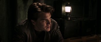 Movie still from “The Darkest Hour” (2011), directed by Chris Gorak – A man sitting in a dark room looking at the camera; Close Up shot, Over the shoulder angle