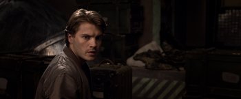 Movie still from “The Darkest Hour” (2011), directed by Chris Gorak – A young man holding an old suitcase in a dark room; Close Up shot, Over the shoulder angle