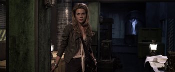 Movie still from “The Darkest Hour” (2011), directed by Chris Gorak – A beautiful young woman holding a purse while standing next to a building; Medium shot, Over the shoulder angle