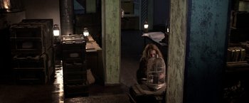 Movie still from “The Darkest Hour” (2011), directed by Chris Gorak – A woman holding a bird cage in a room; Wide shot, High angle