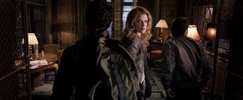 Movie still from “The Darkest Hour” (2011), directed by Chris Gorak – A woman standing next to a man with a backpack; Medium shot, Low angle