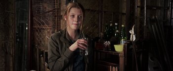 Movie still from “The Darkest Hour” (2011), directed by Chris Gorak – A woman is holding a glass in her hand; Medium shot, Over the shoulder angle