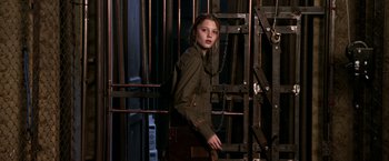 Movie still from “The Darkest Hour” (2011), directed by Chris Gorak – A woman standing next to a metal gate; Medium shot, Low angle