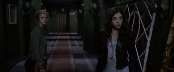 Movie still from “The Darkest Hour” (2011), directed by Chris Gorak – A woman standing in a room with a rug; Medium shot, Over the shoulder angle