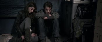Movie still from “The Darkest Hour” (2011), directed by Chris Gorak – A man and a woman sitting next to each other on the floor; Medium shot, Overhead angle