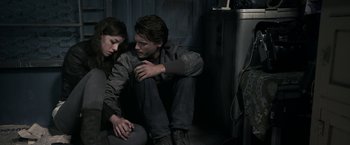 Movie still from “The Darkest Hour” (2011), directed by Chris Gorak – A man and a woman sitting next to each other on the ground; Medium shot, High angle