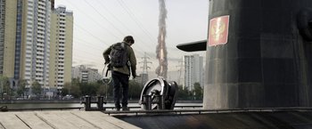 Movie still from “The Darkest Hour” (2011), directed by Chris Gorak – A man with a backpack standing next to a fire hydrant; Wide shot, Low angle