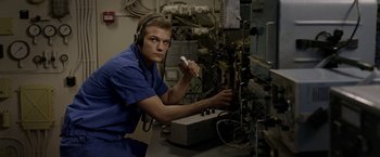 Movie still from “The Darkest Hour” (2011), directed by Chris Gorak – A man in a blue lab coat holding a remote control; Medium shot, Low angle