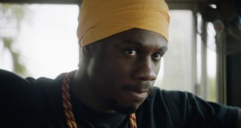 Movie still from “The Day Shall Come” (2019), directed by Christopher Morris – A person wearing a hat; Close Up shot, Low angle