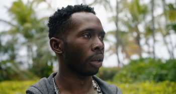 Movie still from “The Day Shall Come” (2019), directed by Christopher Morris – A person wearing a jacket; Close Up shot, Low angle