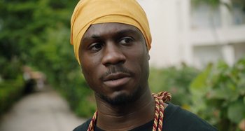 Movie still from “The Day Shall Come” (2019), directed by Christopher Morris – A person wearing a turban; Close Up shot, Low angle