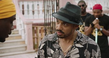 Movie still from “The Day Shall Come” (2019), directed by Christopher Morris – A person wearing a hat; Close Up shot, Over the shoulder angle