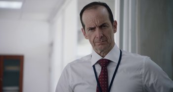 Movie still from “The Day Shall Come” (2019), directed by Christopher Morris – A person wearing a shirt and a tie; Close Up shot, Over the shoulder angle