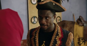 Movie still from “The Day Shall Come” (2019), directed by Christopher Morris – A man wearing a pirate hat and a black jacket; Close Up shot, Over the shoulder angle
