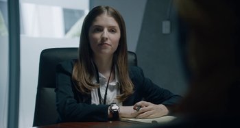 Movie still from “The Day Shall Come” (2019), directed by Christopher Morris – A woman sitting at a desk in an office setting; Close Up shot, Over the shoulder angle