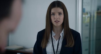 Movie still from “The Day Shall Come” (2019), directed by Christopher Morris – A woman with long hair wearing a white shirt and jacket; Close Up shot, Over the shoulder angle