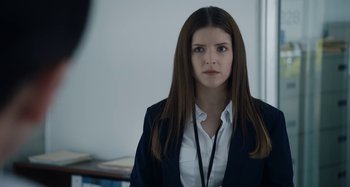 Movie still from “The Day Shall Come” (2019), directed by Christopher Morris – A woman with long hair wearing a white shirt and jacket; Close Up shot, Over the shoulder angle