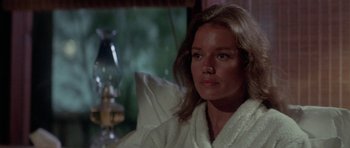 Movie still from “The Day of the Dolphin” (1973), directed by Mike Nichols – A woman in a white bathrobe sitting on a couch; Close Up shot, Over the shoulder angle