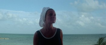 Movie still from “The Day of the Dolphin” (1973), directed by Mike Nichols – A woman with a towel wrapped around her head looking out at the ocean; Close Up shot, Low angle