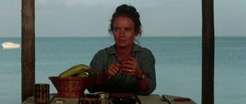 Movie still from “The Day of the Dolphin” (1973), directed by Mike Nichols – A woman sitting at a table with a bowl of fruit; Medium shot, Low angle