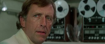 Movie still from “The Day of the Dolphin” (1973), directed by Mike Nichols – A man's face in front of a radio; Close Up shot, Low angle