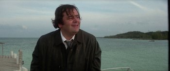 Movie still from “The Day of the Dolphin” (1973), directed by Mike Nichols – A man in a jacket and tie looking at the ocean; Close Up shot, Low angle