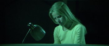 Movie still from “The Day of the Dolphin” (1973), directed by Mike Nichols – A woman sitting in front of a table holding a spoon; Medium shot, Low angle