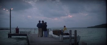 Movie still from “The Day of the Dolphin” (1973), directed by Mike Nichols – A group of people standing on a pier next to the ocean; Extreme Wide shot, High angle