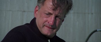 Movie still from “The Day of the Dolphin” (1973), directed by Mike Nichols – A person wearing a black jacket; Close Up shot, Low angle