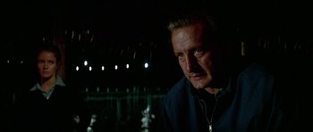 Movie still from “The Day of the Dolphin” (1973), directed by Mike Nichols – A person wearing a jacket near a body of water; Close Up shot, Low angle