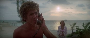 Movie still from “The Day of the Dolphin” (1973), directed by Mike Nichols – A man talking on a phone on the beach; Close Up shot, Low angle