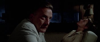 Movie still from “The Day of the Dolphin” (1973), directed by Mike Nichols – A person sitting on a couch; Close Up shot, Low angle