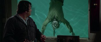 Movie still from “The Day of the Dolphin” (1973), directed by Mike Nichols – A man hanging upside down in the water; Medium shot, Overhead angle