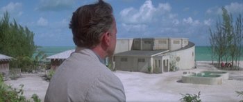 Movie still from “The Day of the Dolphin” (1973), directed by Mike Nichols – A man standing in front of an abandoned building; Extreme Wide shot, Over the shoulder angle
