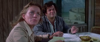 Movie still from “The Day of the Dolphin” (1973), directed by Mike Nichols – A man and a woman sitting at a table; Medium shot, Low angle