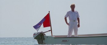 Movie still from “The Day of the Dolphin” (1973), directed by Mike Nichols – A man standing on the front of a boat in the water; Wide shot, Low angle